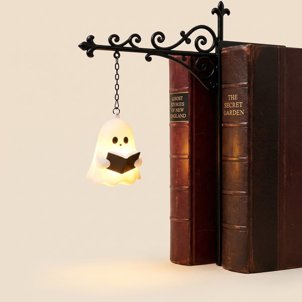 The Reader shelf lantern, a glowing ghost holding a book, hanging between books